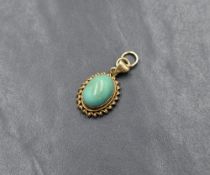 A 9ct gold turquoise pendant, the bezel set turquoise cabochon with a decorative twisted rope