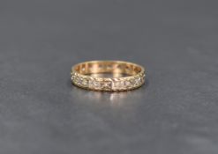 A 9ct gold full eternity band, having illusion set clear gemstones, possibly topaz or sapphire, ring
