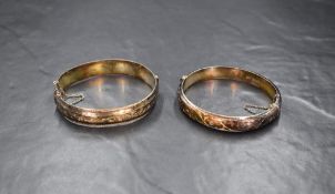 A hinged silver bangle having engraved scroll decoration and concealed clasp, approx 18.6g and