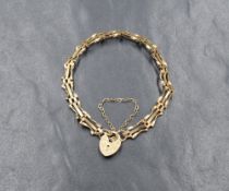 A 9ct gold three bar gate bracelet, having a heart padlock and safety chain, 3.6g