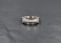 A white metal diamond band, the seven round cut diamonds measuring approximately 0.21 total,