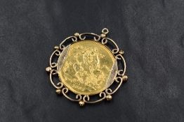 A Victorian 1887 Royal Mint double sovereign, in a decorative unmarked yellow metal scroll and