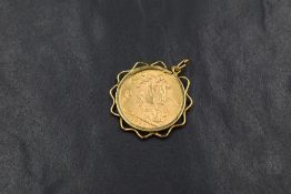 A George V 1927 South Africa sovereign, in a yellow metal wave pattern surround mount with pendant
