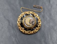 A Victorian yellow metal hair mourning brooch, of circular form having scroll decoration with