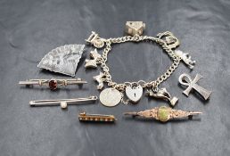 A silver charm bracelet having eight charms including Dachshund, spinning wheel etc, and six white