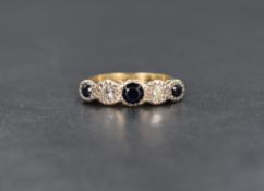 An 18ct gold and platinum sapphire and diamond five stone ring, the central bezel set blue