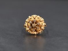 A high carat gold diamond cluster ring, the central seven diamond chip cluster in a floral motif