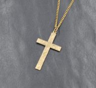 A 9ct gold cross having engraved scroll decoration on a yellow metal chain bearing mark SPAIN18, 24'