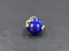 A 9ct gold lapis lazuli and diamond ring, the central circular lapis lazuli cabochon within a