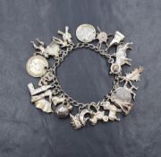 A white metal charm bracelet, having twenty-two charms including a bull, three coins, St. Edward's