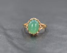 A 9ct gold green gemstone ring possibly chrysoprase, the central cabochon in an eight claw setting