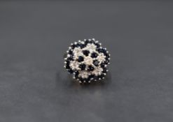 A 9ct gold sapphire and diamond cluster ring, the central illusion set diamond with a six round