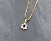 An 18ct gold sapphire and diamond floral cluster pendant, the central round cut sapphire with an