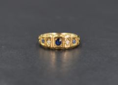 An 18ct gold sapphire and diamond gypsy style ring, the central oval cut blue sapphire flanked by