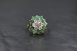 A 9ct gold triple cluster ring having cubic zirconia and emerald style stones in a claw set basket