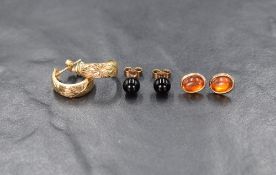 Three pairs of yellow metal earrings of various designs for pierced ears including hoop and Baltic