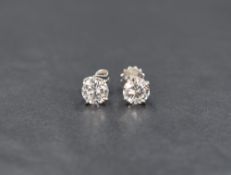 A pair of 14ct white gold diamond solitaire stud earrings, the round brilliant cut diamonds