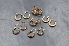 Six pairs of 9ct gold and yellow metal hoop earrings of various designs, approx 5.3g