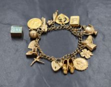 A 9ct gold curb link charm bracelet, having a heart padlock and fifteen 9ct gold and yellow metal