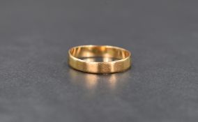 An 18ct gold band, having conforming panels with line engraving, ring size O-P, 1.8g. Ring is