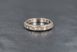 A white metal and diamond half eternity band, the diamond chips in illusion settings, on a shank
