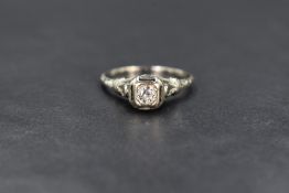 An early 20th century white gold diamond solitaire ring stamped 18K, the stone approx 0.25ct in a