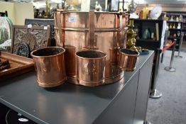 A 19th century polished copper milk bucket having three copper milk measuring cups, h29cm