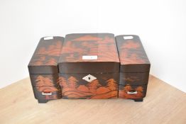 A Chinese lacquered jewellery music box, having two drawers above a metamorphic top revelling a