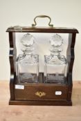 A quality 20th century mahogany two-bottle Tantalus with etching 'Underlay Garden School' and '