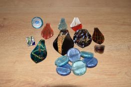 A collection of glass jewellery, comprising seven teardrop pendants, three rings and an expanding