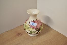 A Moorcroft pottery Hibiscus pattern vase of ovoid form with flared neck and pink flowers on a cream