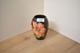 A Moorcroft pottery Hibiscus pattern Ovoid vase, decorated having large blooms on a brown glaze