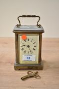 An early 20th century brass carriage clock, having Roman numerals, glass to all sides, carry