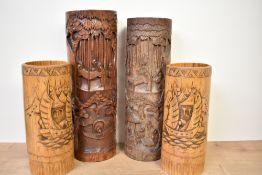 A large early 20th century pair of Chinese bamboo brush pots, carved with scholars in a forest,
