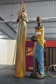A tall resin sculpture of an African woman clutching a water vessel, h41cm, sold together with a