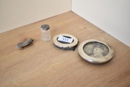 A silver mounted photograph frame, of oval form along with a circular white metal mounted frame, a