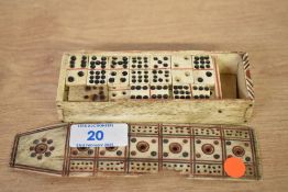 An early 20th century miniature bone domino set with sliding lid and etched circle and dot