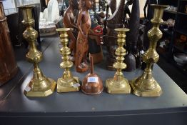 A group of early 20th century brass candlesticks, largest h27cm, sold together with a brewing copper