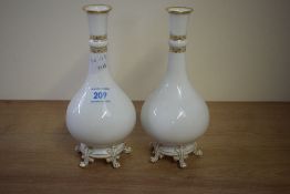 A pair of Sevres porcelain baluster vases with fluted stems and supported on five pew feet, makers
