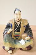 A Japanese stoneware figure of a seated man with a box by his side, h14cm Condition report: