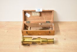 A late 19th / early 20th century field brass microscope, having original wooden case, makers label
