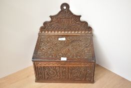 A 19th century oak candle box, decorated with carved geometric patterns, w30cm