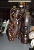 A large Indonesian hand carved hardwood sculpture, h44cm, sold together with a carved wooden child