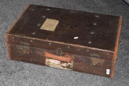 An early 20th century canvas suitcase, having solid brass fittings, leather handle and original