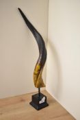 A replica Goat or Antelope twisted horn sculpture supported on resin base, h52cm.
