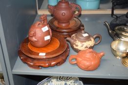 Four Chinese Yixing teapots, each decorated with relief moulded dragon designs, with two circular