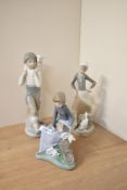 A Lladro porcelain figurine 'Girl with Milk Pail' number 4682 sold together with two Nao by Lladro