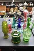 A Mary Gregory style green glass ewer with stopper, decorated with a girl amongst a landscape,