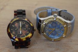 Two Guess wristwatches, one having a blue snake print dial with two subsidiary dials on a metallic