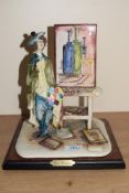 An Italian hand-painted ceramic figure depicting a youthful artist in a studio setting on wooden